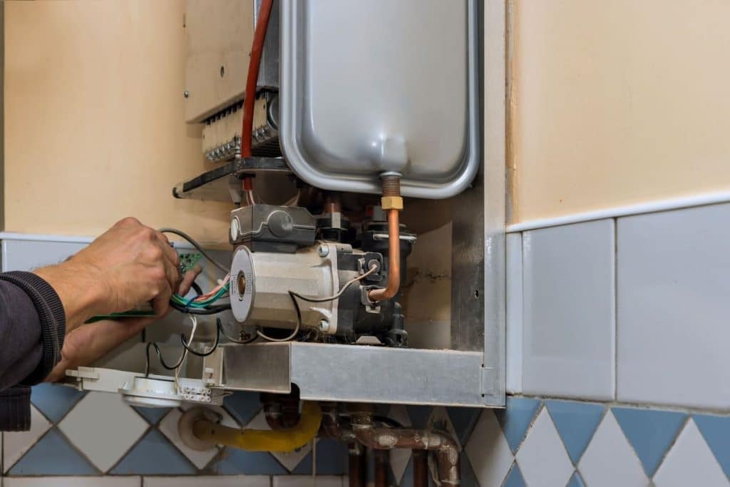 Gas water heater maintenance technician doing repairs